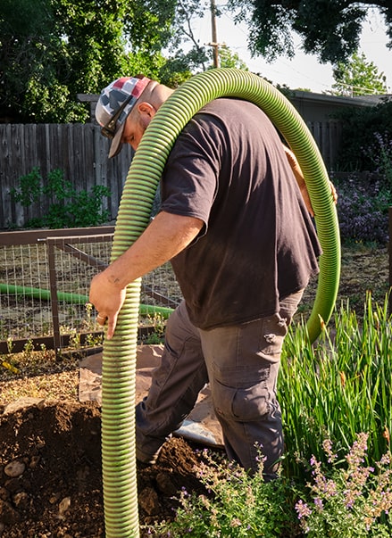 a chico septic employee lowering the pump hose into the septic tank