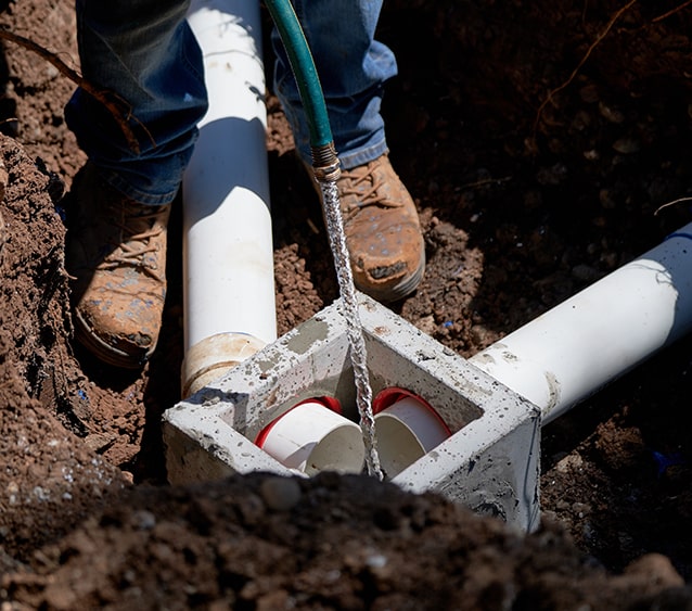 intersecting white pipe in a dirt trench